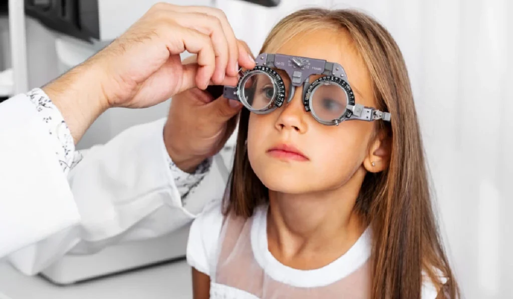کودکی در حال معاینه شدن چشم هایش برای عینک طبی